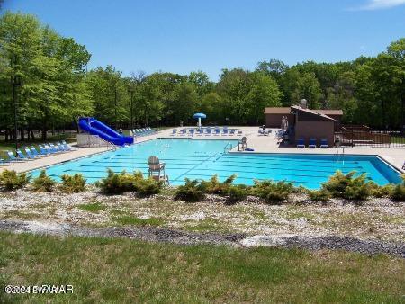 view of swimming pool with a patio area and a water slide