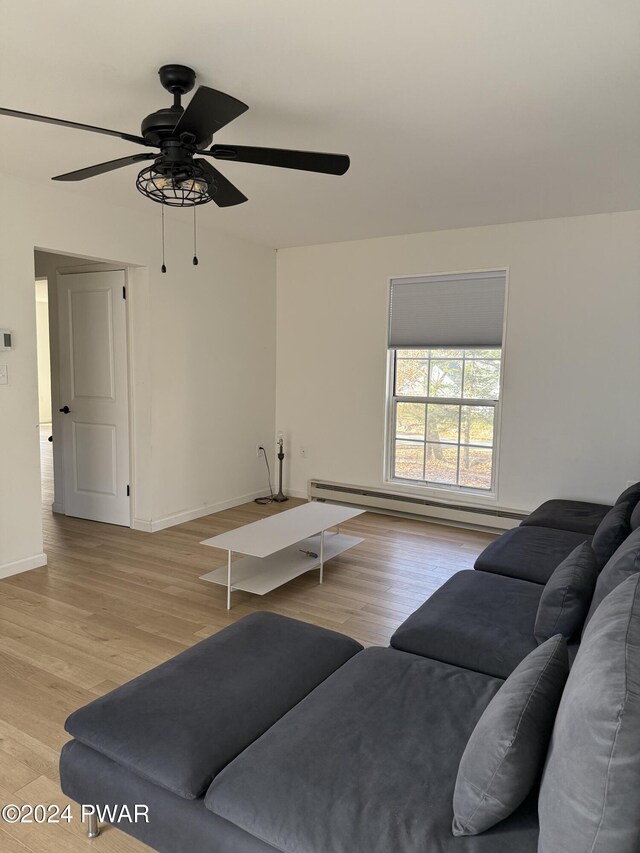 living room with light hardwood / wood-style floors, ceiling fan, and a baseboard heating unit