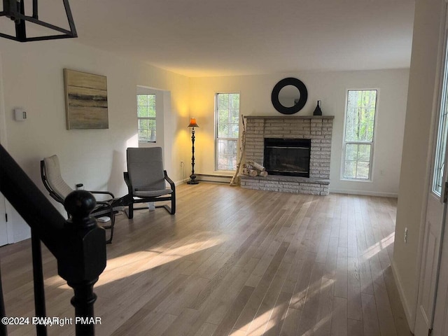 living room featuring hardwood / wood-style flooring, a brick fireplace, and a wealth of natural light