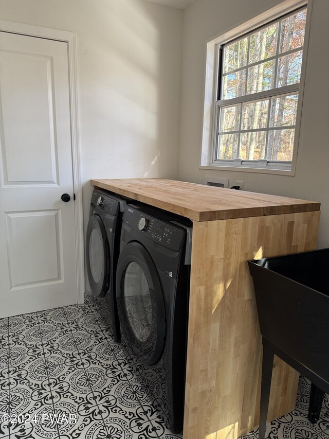 washroom featuring light tile patterned floors and washer and clothes dryer