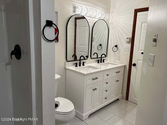 bathroom with tile patterned flooring, vanity, and toilet