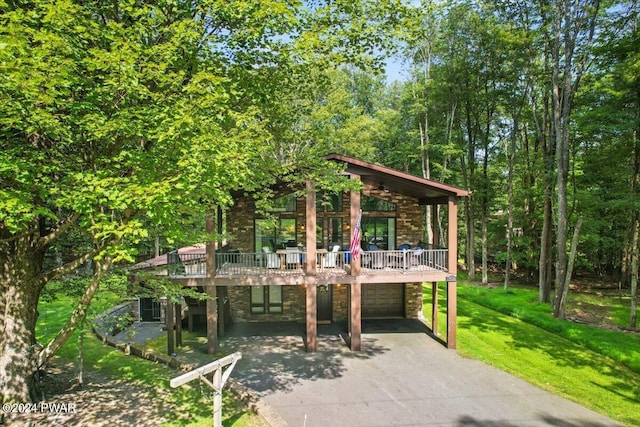 49 White Pine Cir, Lake Ariel, PA 18436 - view of front of property featuring asphalt driveway, a front yard, a wooden deck, an attached garage, and stone siding
