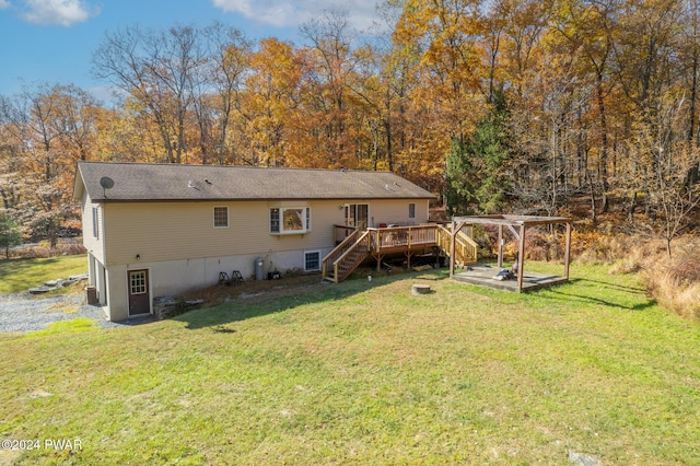 rear view of house with a pergola, a deck, and a lawn