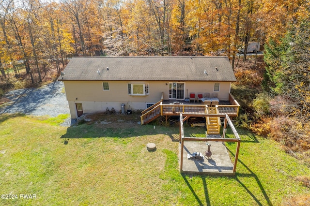 rear view of property featuring a yard and a wooden deck