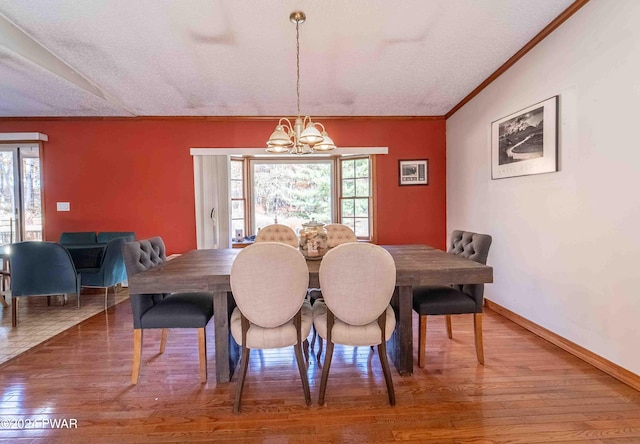 dining space featuring a chandelier, a textured ceiling, and hardwood / wood-style flooring