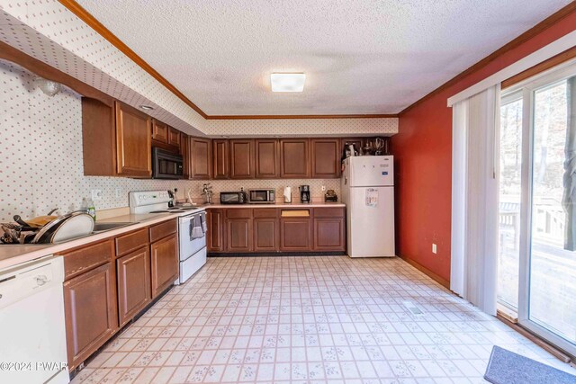 kitchen featuring a textured ceiling, sink, white appliances, and crown molding