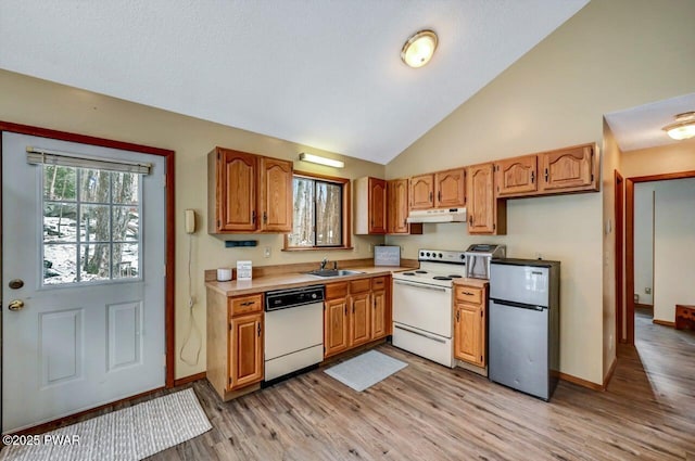 kitchen with under cabinet range hood, a sink, white appliances, light wood-style floors, and light countertops