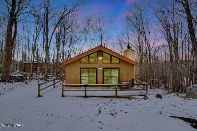 snow covered property with a chimney