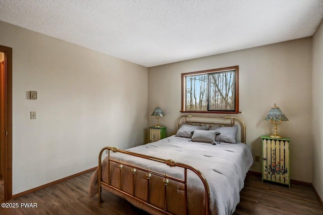 bedroom featuring dark wood-type flooring, baseboards, and a textured ceiling