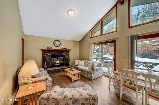 living room with a fireplace, high vaulted ceiling, and wood finished floors