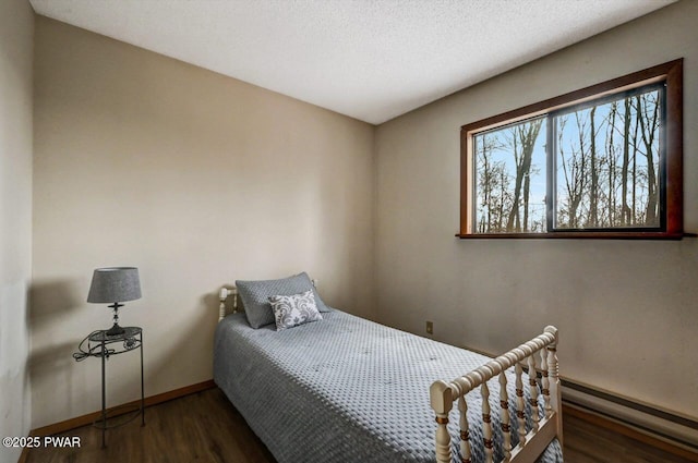 bedroom with a textured ceiling, baseboards, and wood finished floors