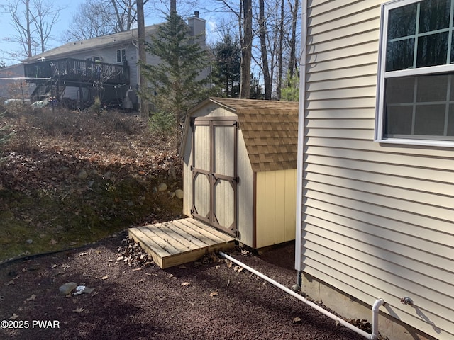 exterior space with an outdoor structure, roof with shingles, a shed, and a chimney