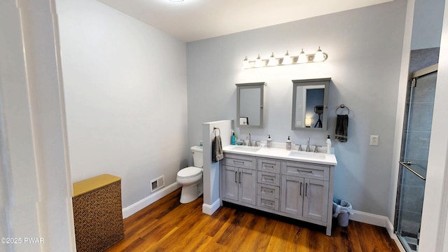 504 St Ives Ct, Bushkill, PA 18324 - full bathroom featuring toilet, double vanity, wood finished floors, and a shower stall