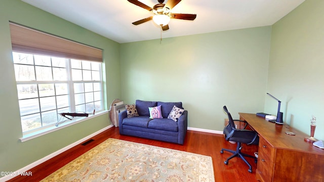 office with wood finished floors, visible vents, a ceiling fan, and baseboards