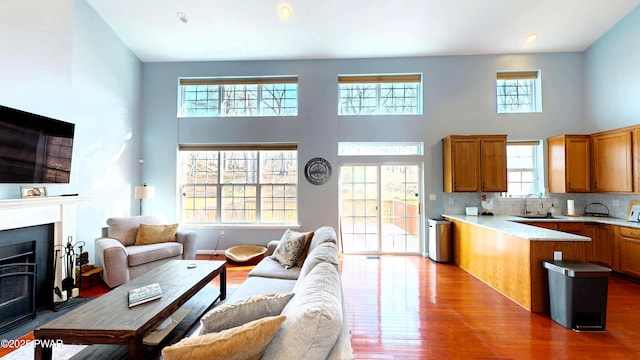 504 St Ives Ct, Bushkill, PA 18324 - living area featuring healthy amount of natural light, a high ceiling, wood finished floors, and a fireplace with flush hearth