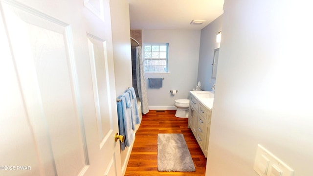 bathroom featuring wood finished floors, toilet, vanity, a shower with curtain, and baseboards