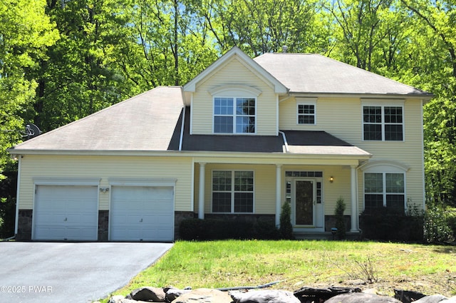 504 St Ives Ct, Bushkill, PA 18324 - view of front facade with asphalt driveway, a garage, a front yard, and a porch