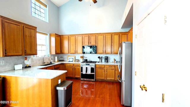 504 St Ives Ct, Bushkill, PA 18324 - kitchen with appliances with stainless steel finishes, a sink, a towering ceiling, healthy amount of natural light, and tasteful backsplash