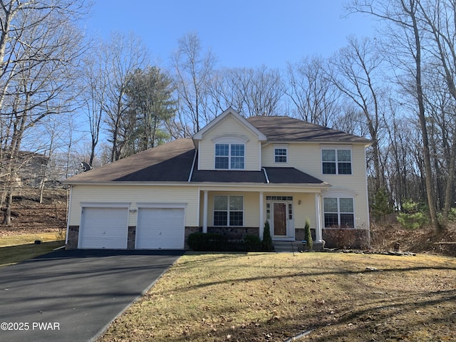 traditional-style home with an attached garage, stone siding, driveway, and a front yard