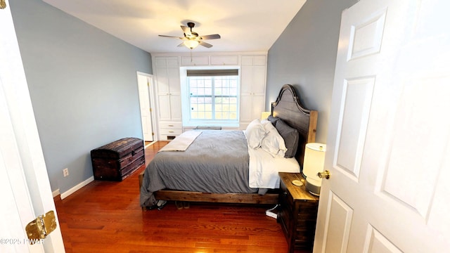 bedroom with ceiling fan, baseboards, and wood finished floors