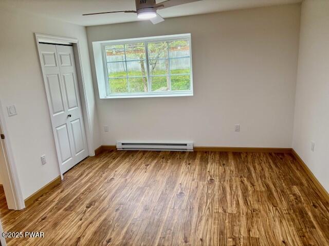9 Wallenpaupack Dr, Lake Ariel, PA 18436 - spare room with a baseboard radiator, a ceiling fan, and wood finished floors