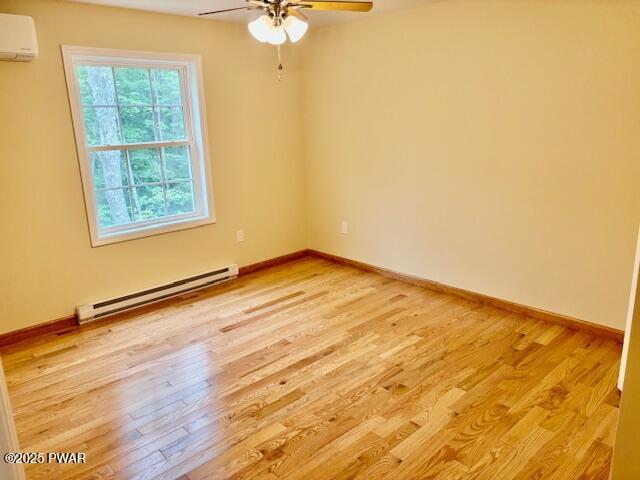 9 Wallenpaupack Dr, Lake Ariel, PA 18436 - unfurnished room featuring a baseboard heating unit, a wall mounted air conditioner, ceiling fan, and light wood-style floors