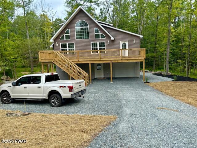 9 Wallenpaupack Dr, Lake Ariel, PA 18436 - chalet / cabin featuring an attached garage, gravel driveway, a deck, and a view of trees