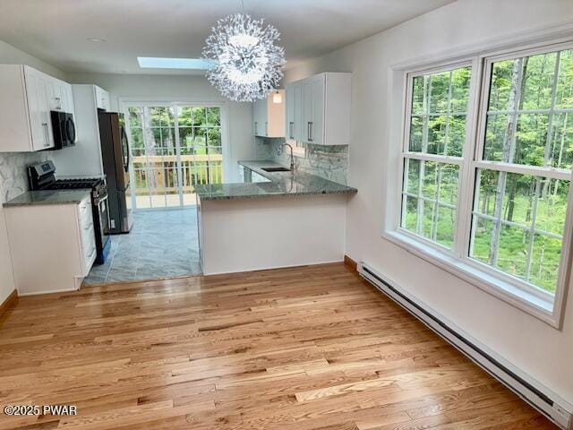 9 Wallenpaupack Dr, Lake Ariel, PA 18436 - kitchen featuring gas range, baseboard heating, black microwave, freestanding refrigerator, and light wood finished floors