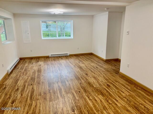 9 Wallenpaupack Dr, Lake Ariel, PA 18436 - unfurnished room featuring a baseboard radiator, a baseboard heating unit, wood finished floors, and plenty of natural light