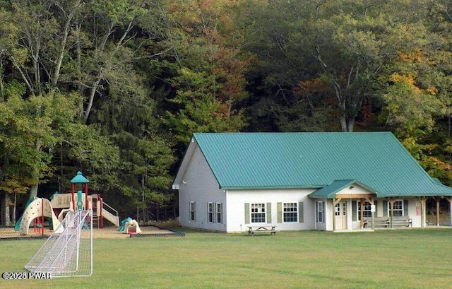 9 Wallenpaupack Dr, Lake Ariel, PA 18436 - view of front of house with a playground, a front lawn, a metal roof, and a wooded view
