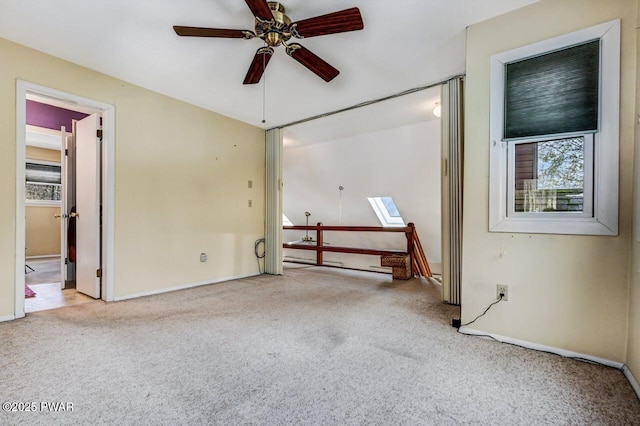 carpeted spare room featuring a healthy amount of sunlight and ceiling fan