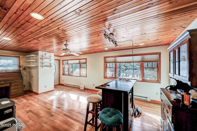 kitchen featuring ceiling fan, a baseboard radiator, a center island, and light hardwood / wood-style floors