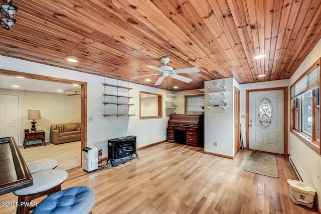 entryway with a wood stove, a baseboard heating unit, ceiling fan, wooden ceiling, and light wood-type flooring