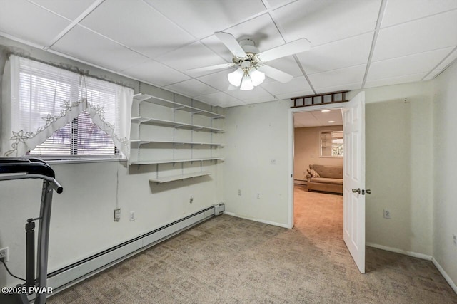 empty room featuring baseboard heating, a paneled ceiling, light carpet, and a wealth of natural light