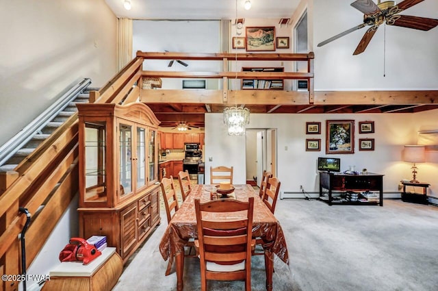 carpeted dining space with a towering ceiling and ceiling fan