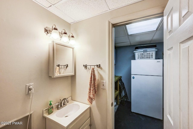 bathroom featuring a drop ceiling, vanity, and concrete flooring