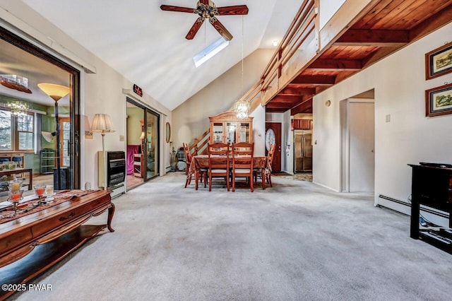 carpeted dining space featuring ceiling fan, lofted ceiling with skylight, and heating unit