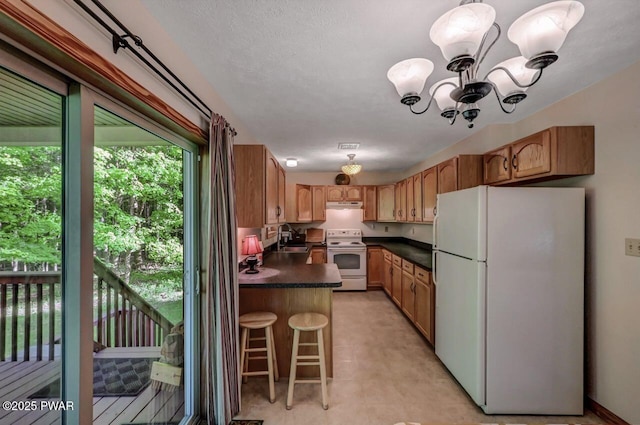 32 Forest Ln, Lake Ariel, PA 18436 - kitchen featuring white appliances, a sink, dark countertops, a chandelier, and under cabinet range hood