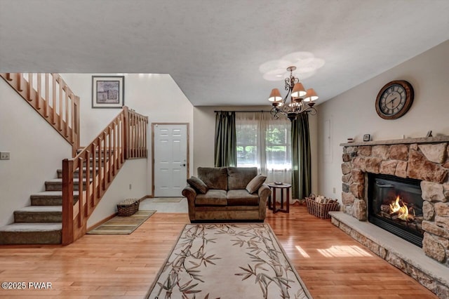 32 Forest Ln, Lake Ariel, PA 18436 - living area featuring light wood finished floors, stairway, a stone fireplace, and a chandelier