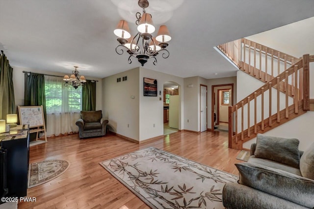 32 Forest Ln, Lake Ariel, PA 18436 - living room featuring a chandelier, arched walkways, wood finished floors, and stairs