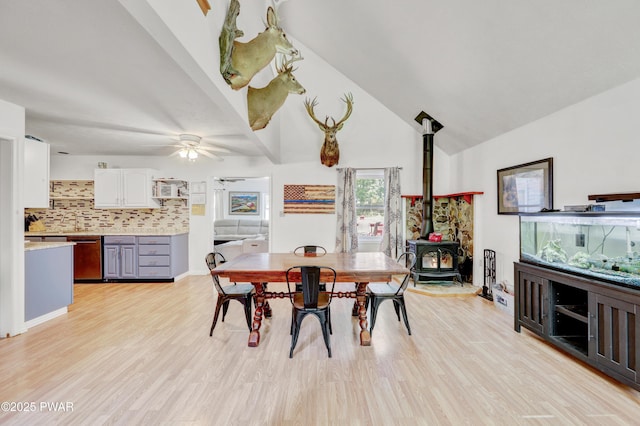 101 Bayberry Dr, Milford, PA 18337 - dining room with a wood stove, a ceiling fan, light wood-style flooring, and high vaulted ceiling