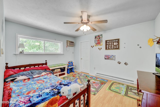 101 Bayberry Dr, Milford, PA 18337 - bedroom featuring baseboard heating, an AC wall unit, wood finished floors, a ceiling fan, and a textured ceiling