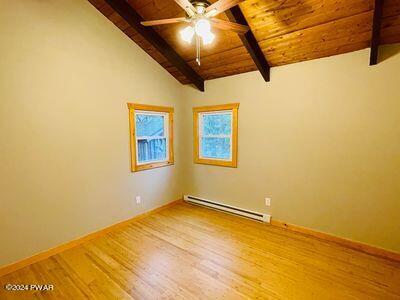 spare room featuring wooden ceiling, lofted ceiling with beams, ceiling fan, a baseboard radiator, and wood-type flooring