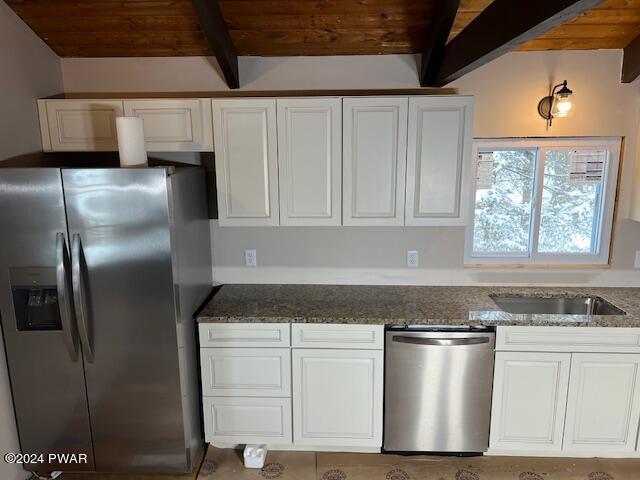 kitchen with dark stone countertops, white cabinetry, wooden ceiling, and appliances with stainless steel finishes