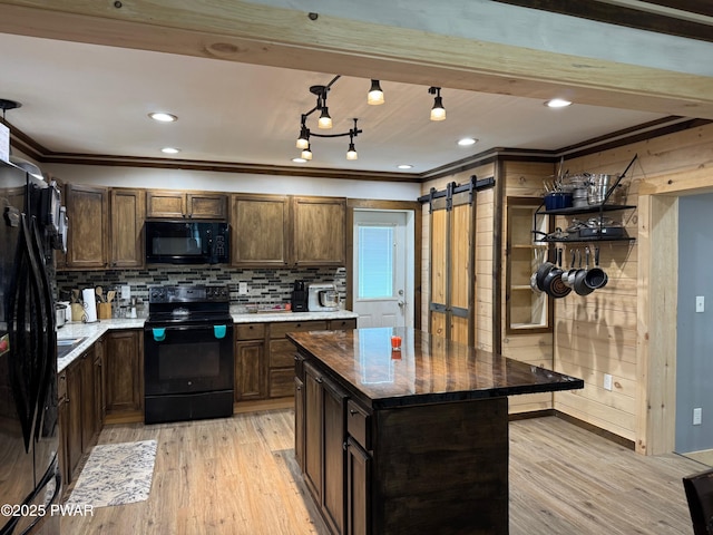 8 Kaiser Strasse, Beach Lake, PA 18405 - kitchen featuring black appliances, light wood finished floors, tasteful backsplash, ornamental molding, and a barn door