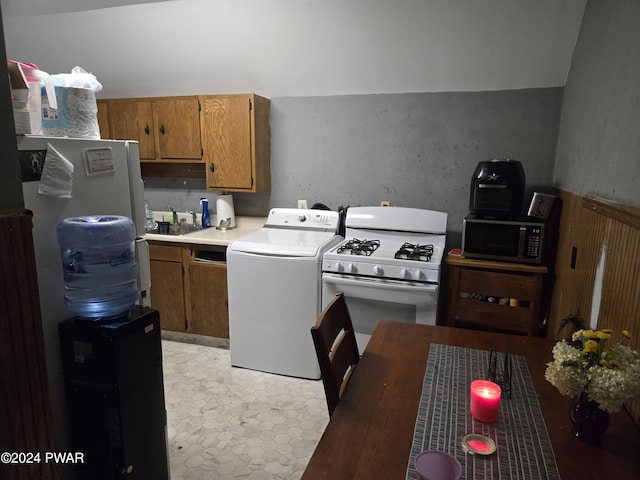 kitchen featuring fridge, washer / clothes dryer, white gas range, and sink