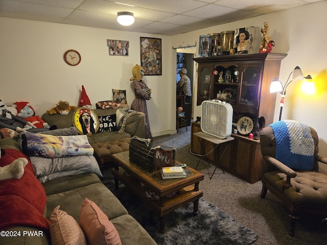 living room with a drop ceiling and carpet floors