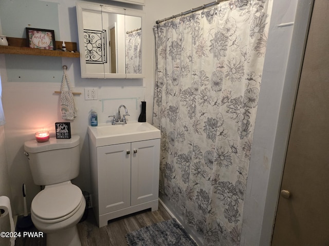 bathroom with walk in shower, toilet, vanity, and hardwood / wood-style flooring