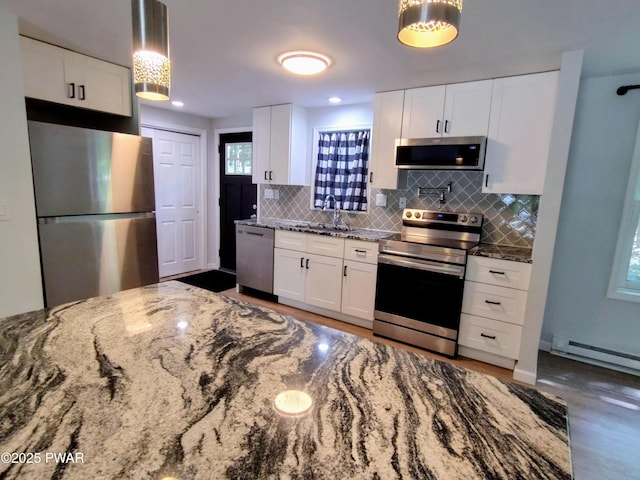 104 Radcliff Rd, Bushkill, PA 18324 - kitchen with appliances with stainless steel finishes, baseboard heating, tasteful backsplash, stone countertops, and a sink