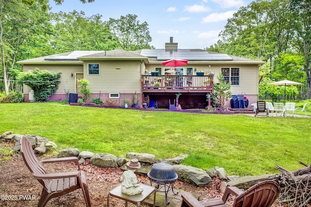 1419 Bear Dr, Bushkill, PA 18324 - rear view of house featuring a deck, solar panels, a chimney, and a lawn